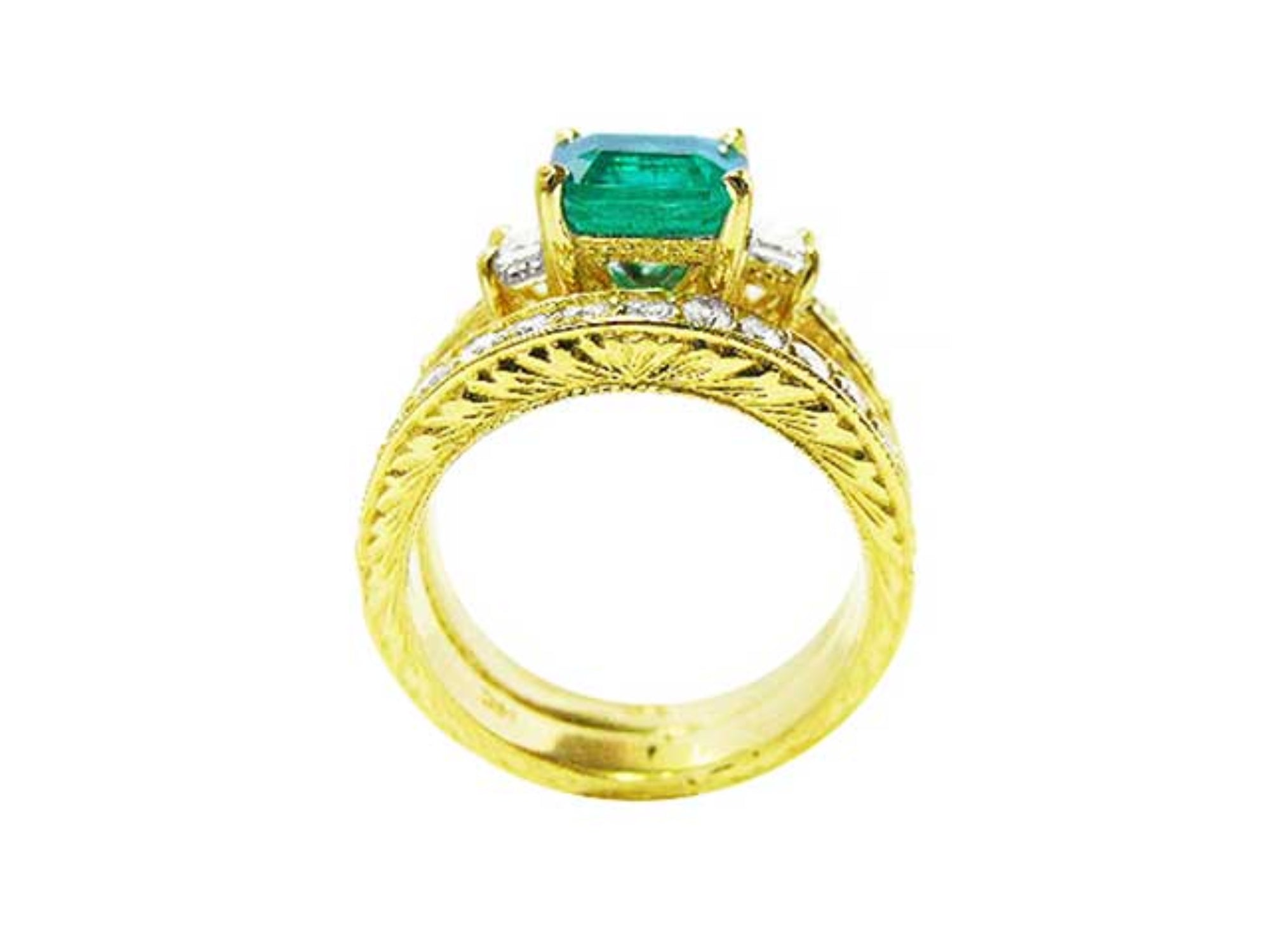 Lateral profile view of a bridal wedding band with diamonds in front of the main emerald ring.
