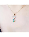 14K gold butterfly pendant with pavé diamonds and a pear-shaped Colombian emerald.