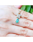 14K gold butterfly pendant with pavé diamonds and a pear-shaped Colombian emerald.