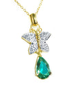 Gold necklace with a natural emerald teardrop pendant and butterfly design on a topside view.