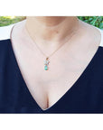 14K gold butterfly pendant with pavé diamonds and a pear-shaped Colombian emerald.