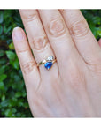 Women's Two-stone "You and Me" blue natural sapphire bypass ring, handcrafted in 18k yellow gold with its distinctive twisted-band silhouette.