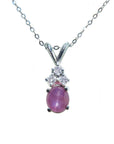 This necklace pendant slider showcases a natural oval pink sapphire cabochon and is crafted in 14k white gold.