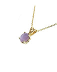 Necklace with a cabochon oval cut pink sapphire pendant in 14k yellow gold.