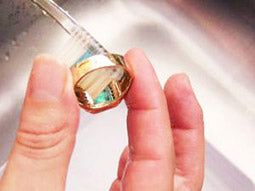 Brushing emerald ring underside to remove dirt