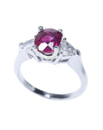 Women's 14k white gold ring with a deep red oval ruby and two trillion side diamonds.