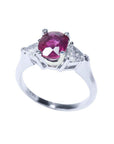 Women's 14k white gold ring with a deep red oval ruby and two trillion side diamonds.