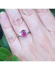 Women's 14k white gold ring with a deep red oval ruby and trillion side diamonds.