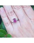 Women's 14k white gold ring with a deep red oval ruby and trillion side diamonds.