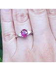 Women's 14k white gold ring with a deep red oval ruby and two trillion side diamonds.