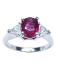Women's 14k white gold ring with a deep red oval ruby and two trillion side diamonds.