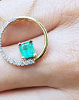 Emerald Bridal circle of life pendant necklace held in a hand