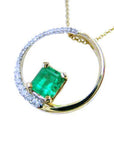 Gold necklace meaning the circle of life with a natural emerald and circular design on a white background.