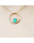 14K gold "Circle of Life" pendant with a rectangular emerald center stone and half pavé diamonds.