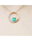 14K gold "Circle of Life" pendant with a rectangular emerald center stone and half pavé diamonds.