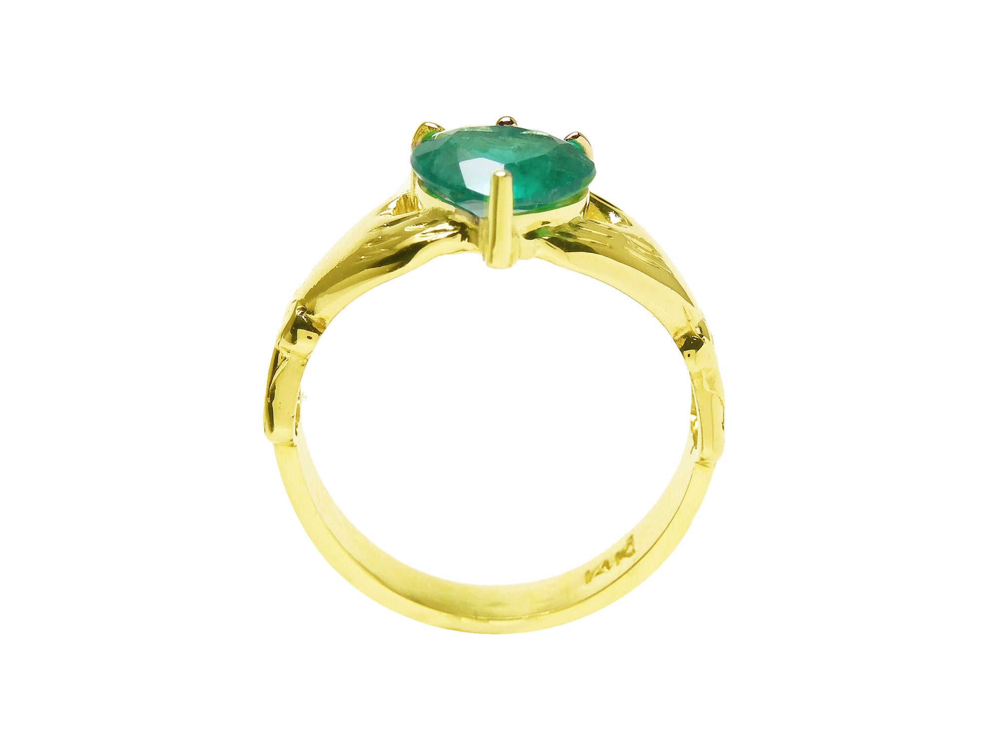 An emerald claddagh rin in yellow gold on a lateral side position top setting and band visibles.