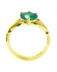 An emerald claddagh rin in yellow gold on a lateral side position top setting and band visibles.