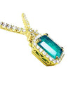 Emerald halo necklace with natural diamonds on a 14K yellow gold chain.