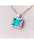 1.31 ct emerald-cut Muzo Colombian emerald necklace with diamond halo on 14K yellow gold chain.