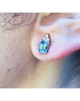 Close-up of an ear wearing a blue sapphire earring.