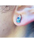 Natural sapphire earrings feature a medium-light blue color, prong-set and topped with sparkling natural diamond on an ear.