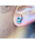 Natural sapphire earrings feature a medium-light blue color, prong-set and topped with sparkling natural diamond on an ear.