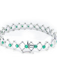A clos-up view of a closure system on a white gold emerald bracelet on a white background.