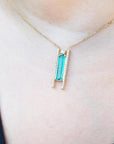 Emerald baguette cut necklace with natural diamonds, 14K yellow gold chain, and unique sliding tube bail.