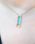 Emerald baguette cut necklace with natural diamonds, 14K yellow gold chain, and unique sliding tube bail.