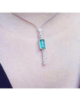 White gold necklace with a rectangular Colombian emerald pendant and diamond accents.