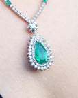 closer view of an emerald necklace with a green teardrop pendant on a women's neck