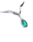 Close view of a pear cut emerald necklace sourced from Muzo mines crafted in 14k white gold, on a white background