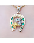 18K yellow gold horseshoe pendant with emeralds, diamonds, and two horse heads.