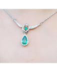 14K white gold necklace with a pear-shaped emerald pendant surrounded by diamonds.