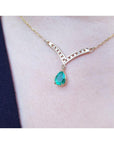 1.01 carat pear cut emerald necklace with accent diamonds set in 14K yellow gold.