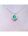 A closer view of a yellow gold necklace with a natural Muzo emerald gemstone pendant on a women's neck