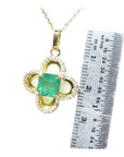 14K gold clover pendant with a square Colombian emerald and diamond accents, shown with a ruler for size.