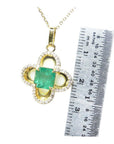 14K gold clover pendant with a square Colombian emerald and diamond accents, shown with a ruler for size.