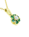 18k yellow gold necklace with a center diamond surrounded by emeralds cluster pendant.