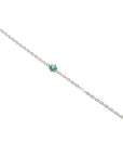 14K yellow gold bracelet with a central cluster of six green emeralds and one diamond.