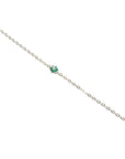 14K yellow gold bracelet with a central cluster of six green emeralds and one diamond.