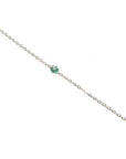 14K yellow gold bracelet with a central cluster of six green emeralds and one diamond.