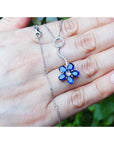 On a person's hand displaying a cluster of natural sapphires pendant white gold necklace white gold chain