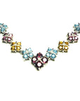 18K white gold necklace with tri-colored topaz X-cluster links and a diamond accent.