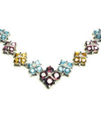 18K white gold necklace with tri-colored topaz X-cluster links and a diamond accent.