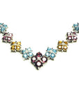 18K white gold necklace with tri-colored topaz X-cluster links and a diamond accent.