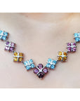18K white gold necklace with tri-colored topaz X-cluster links and a central diamond.