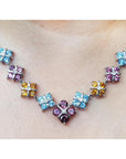 18K white gold necklace with tri-colored topaz X-cluster links and a central diamond.