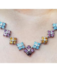18K white gold necklace with tri-colored topaz X-cluster links and a central diamond.