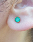 close-up of an earlobe with a Colombian emerald cocktail earring.